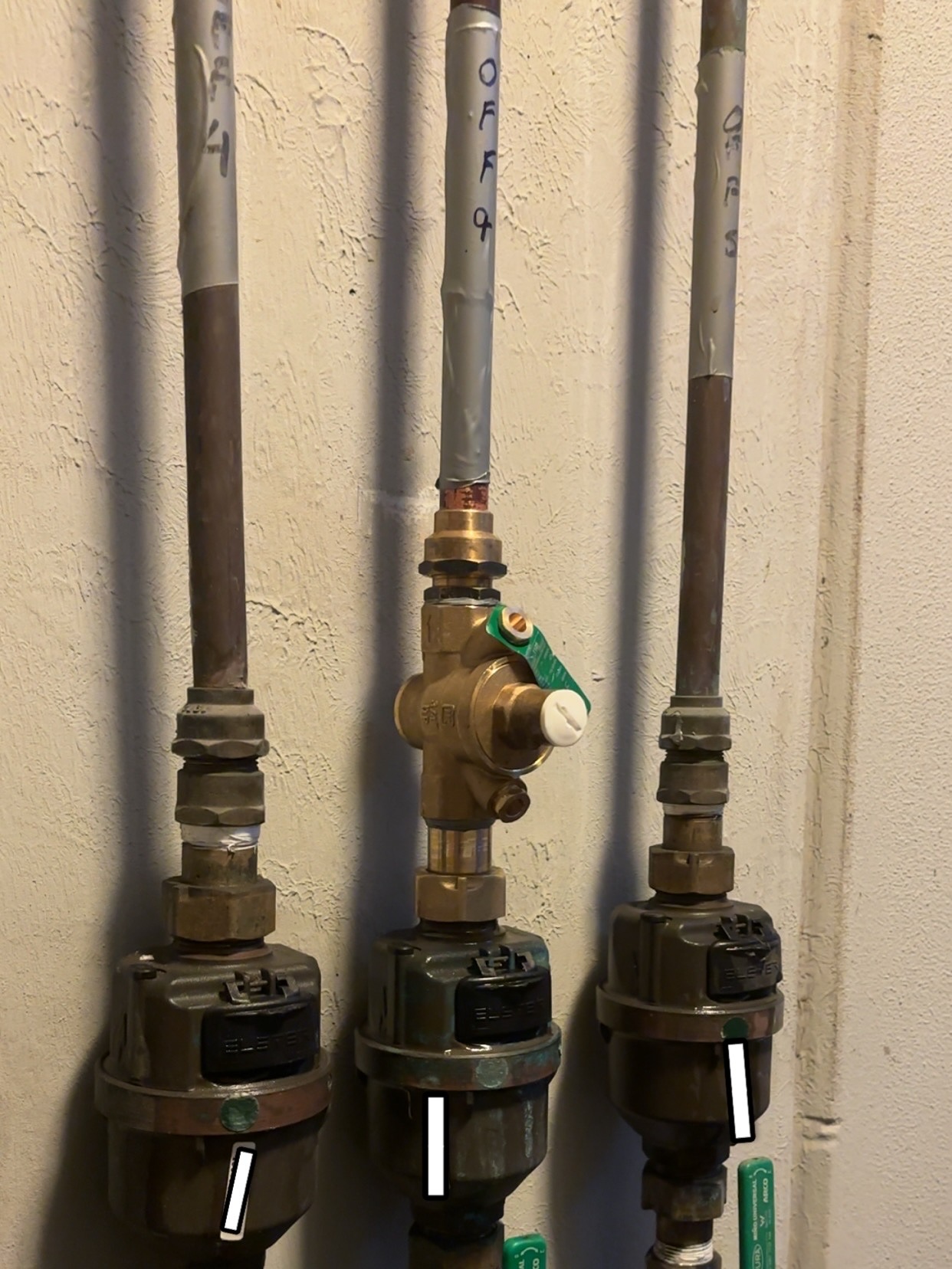Three water meters with pressure limiting valve in strata apartment building Melbourne